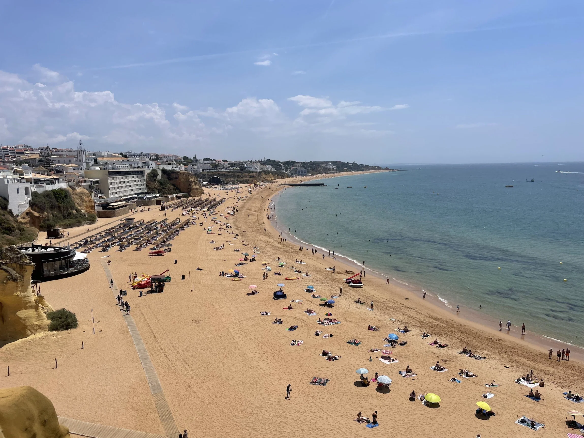 A wide sandy beach backed by a clifftop town