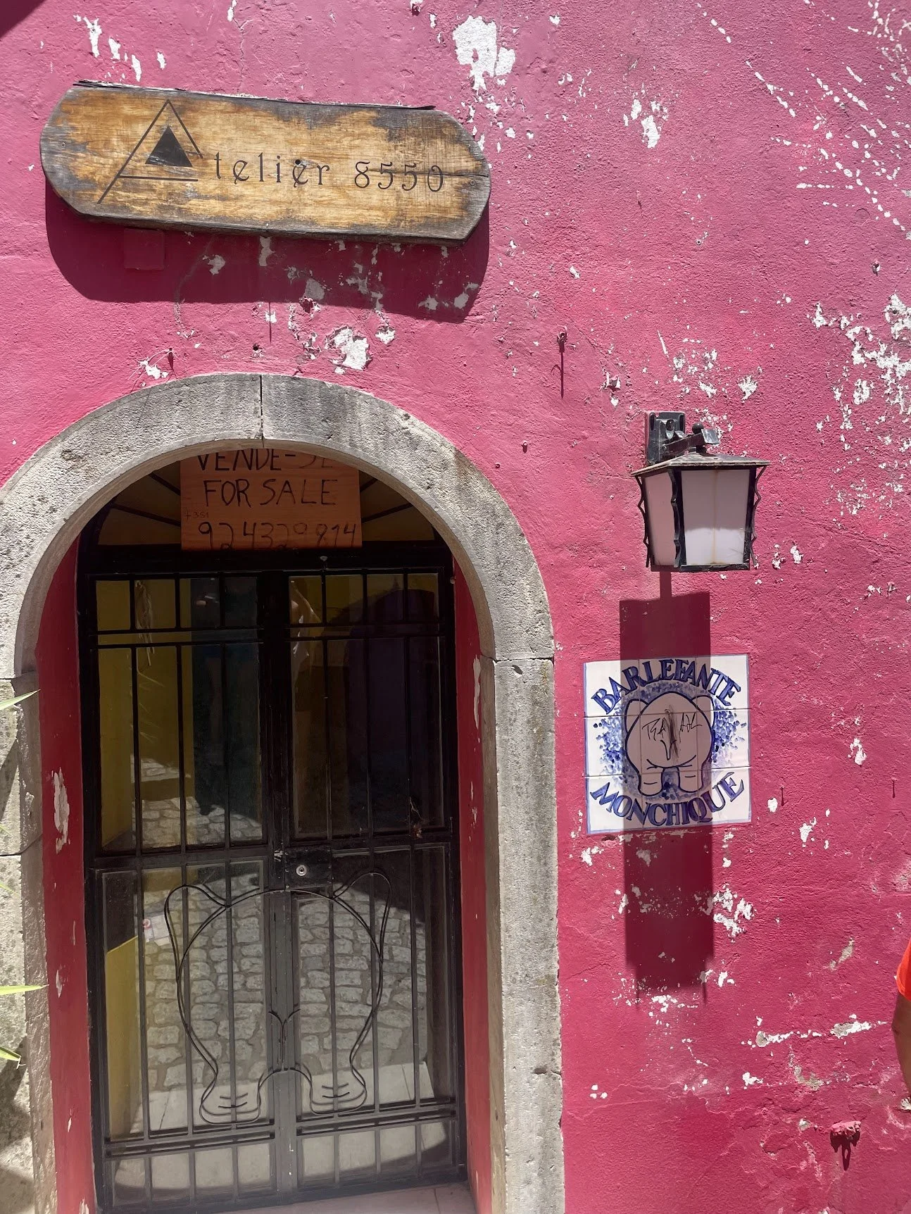 A pink-painted archway doorway in a historic Algarve town