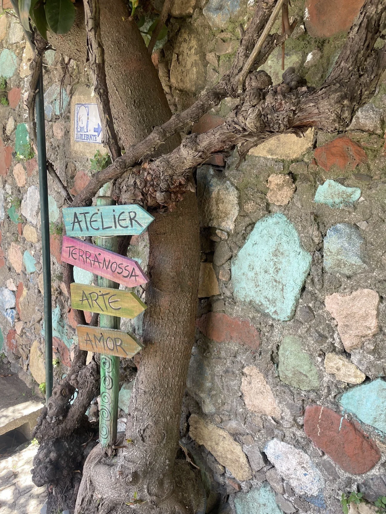 A tree trunk decorated with painted ceramic tiles