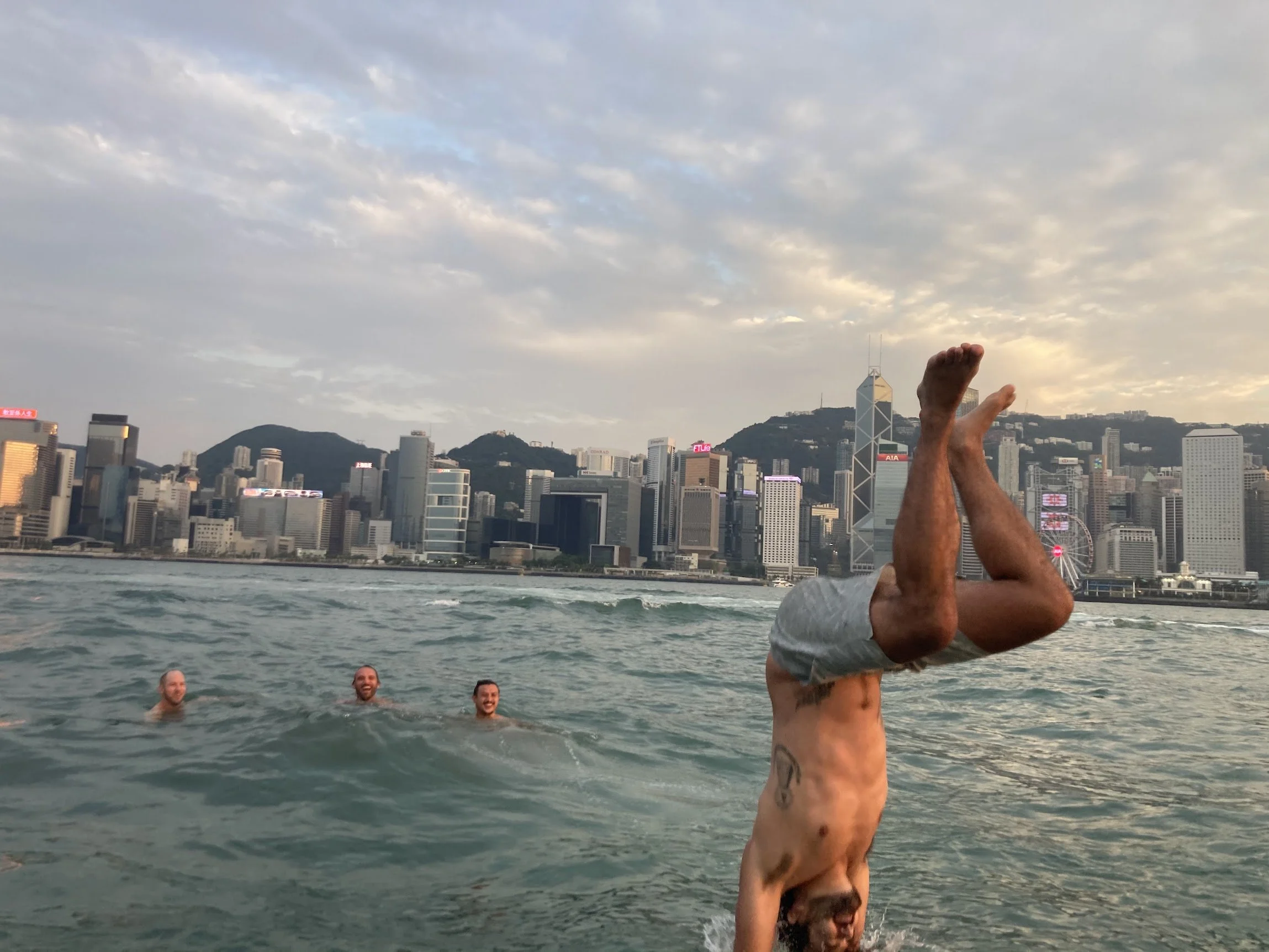 A handstand on the beach with the city skyline behind