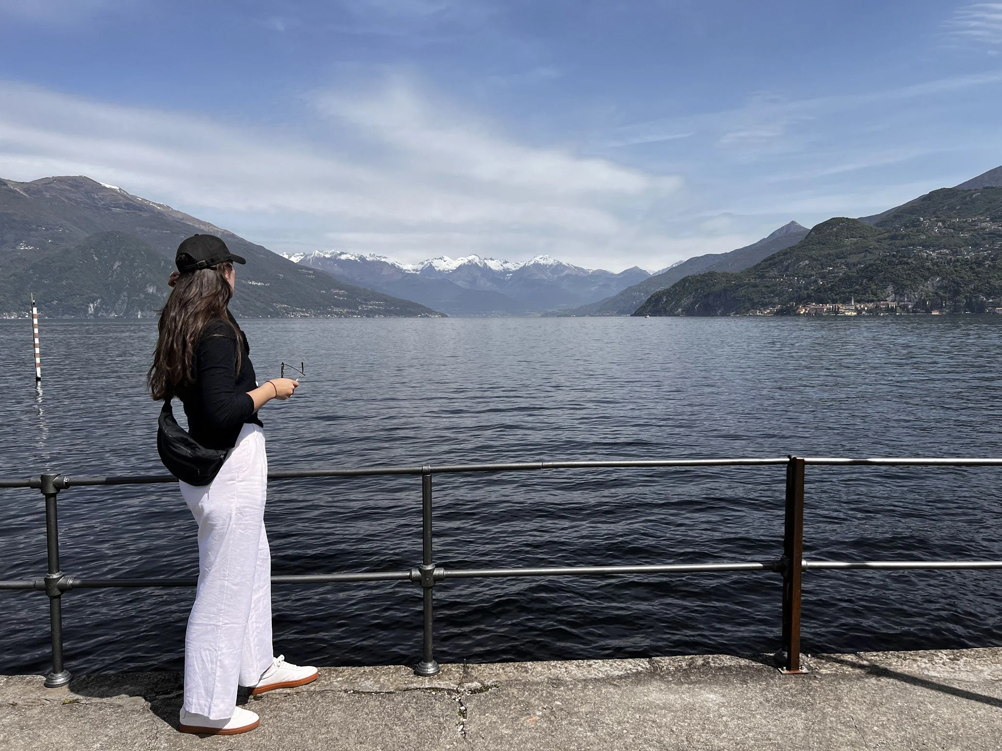 A woman in white admiring the lake from a railing