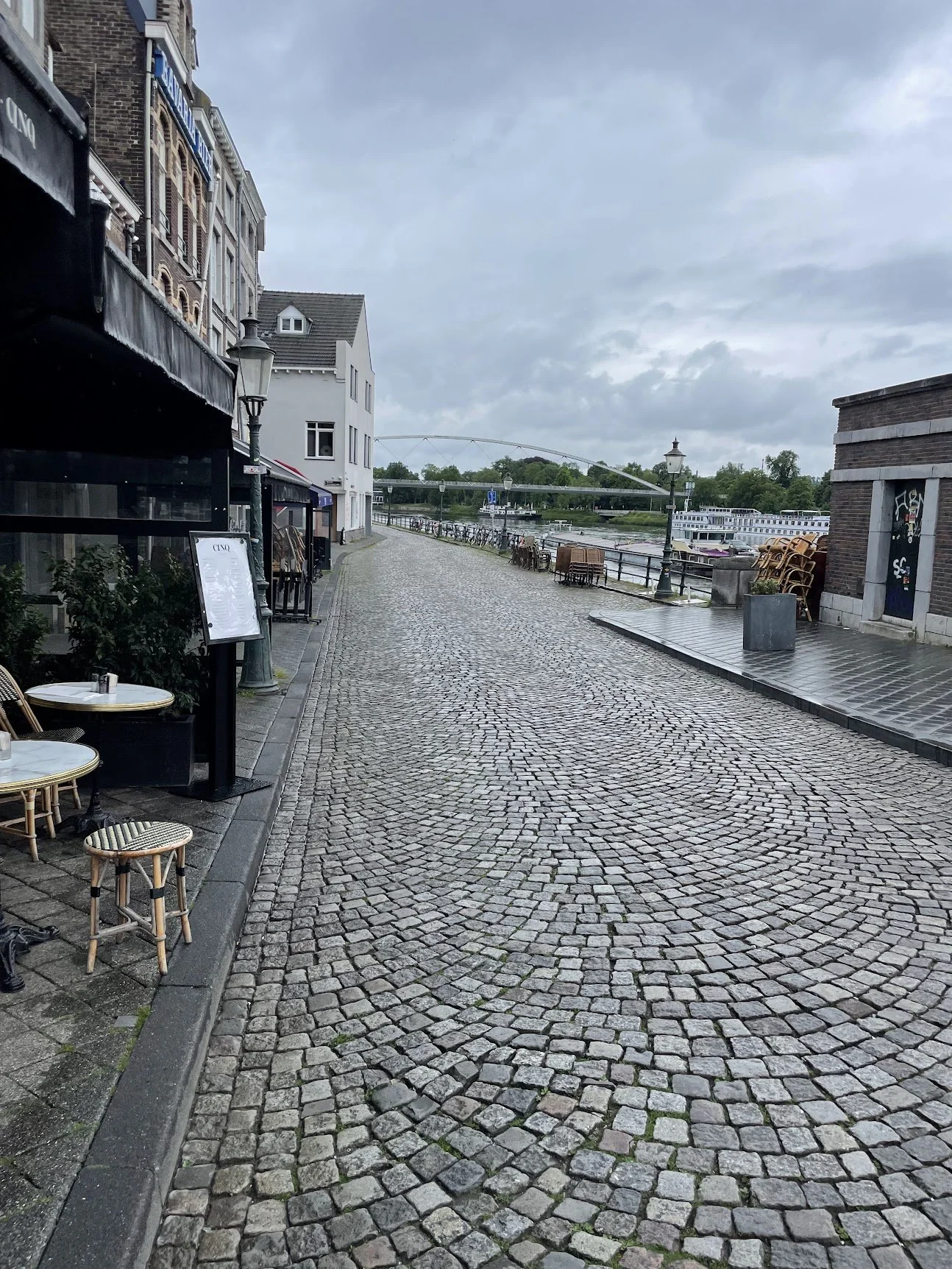 A rain-washed cobbled street lined with old townhouses