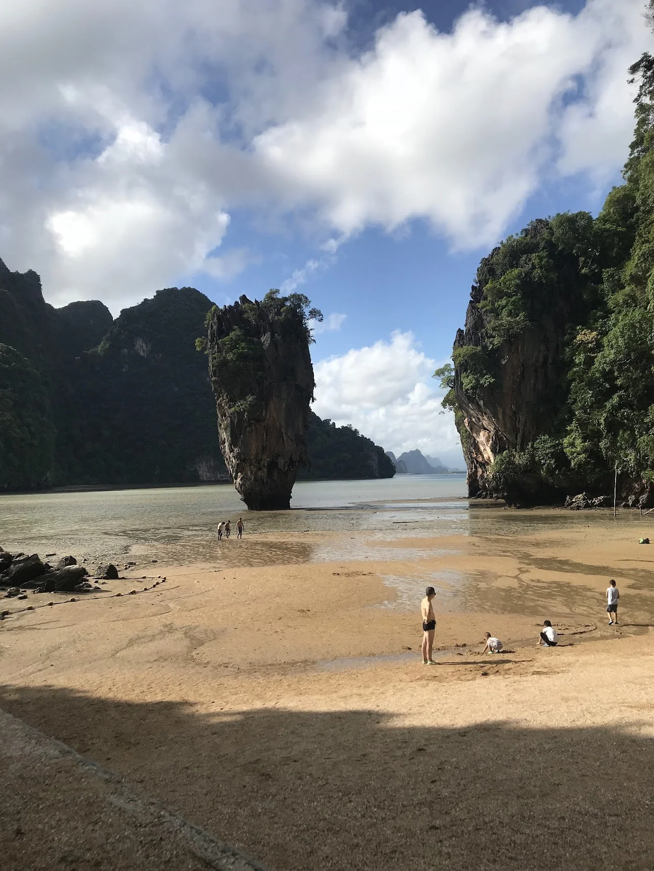 A beach beneath towering limestone cliffs in Phang Nga Bay