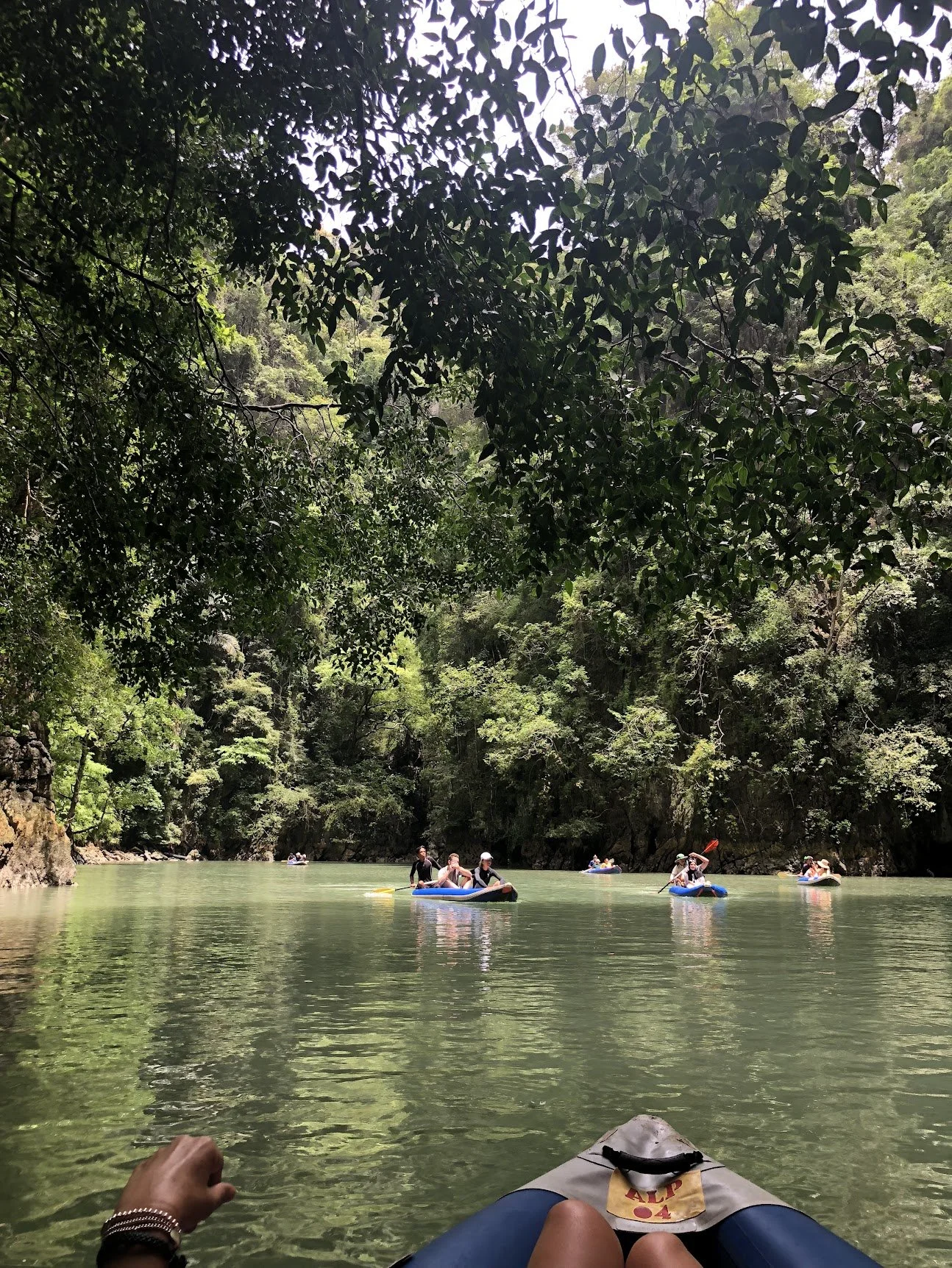 Swimmers exploring the cliffs and emerald water