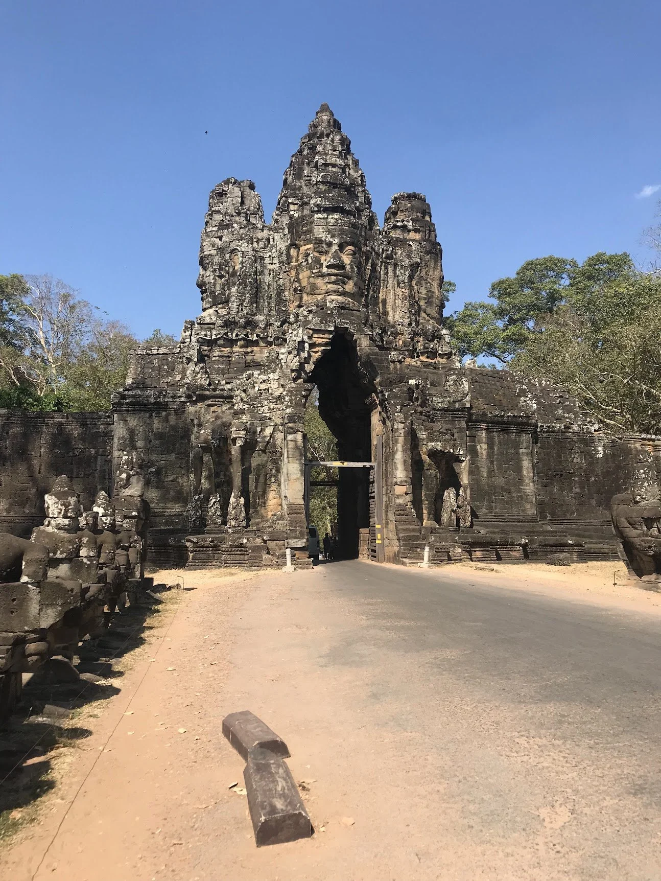 The monumental gate of Angkor Thom along a forest road